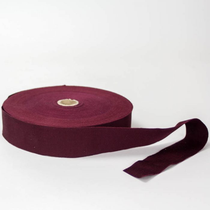 Burgundy. Made in France. Blend of 44% rayon/ 56% cotton grosgrain belting with a saw-tooth edge.